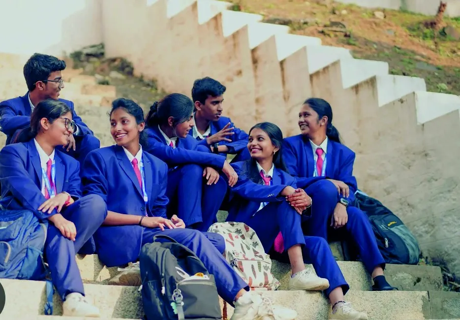 College students in navy blazers and striped ties sitting together on stone steps