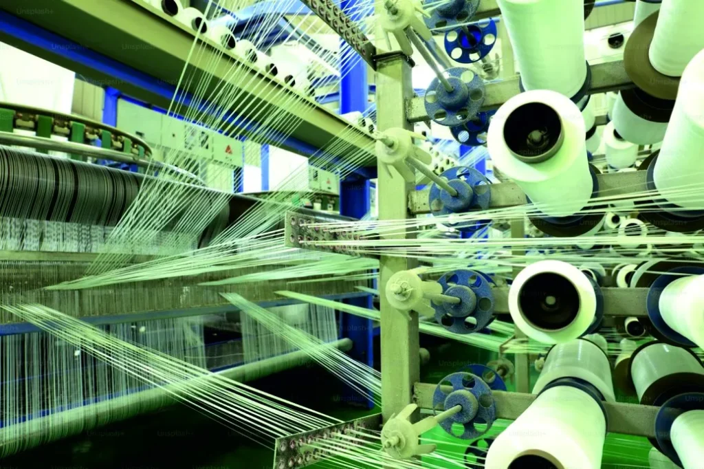 White yarn cones feeding threads into a textile machine