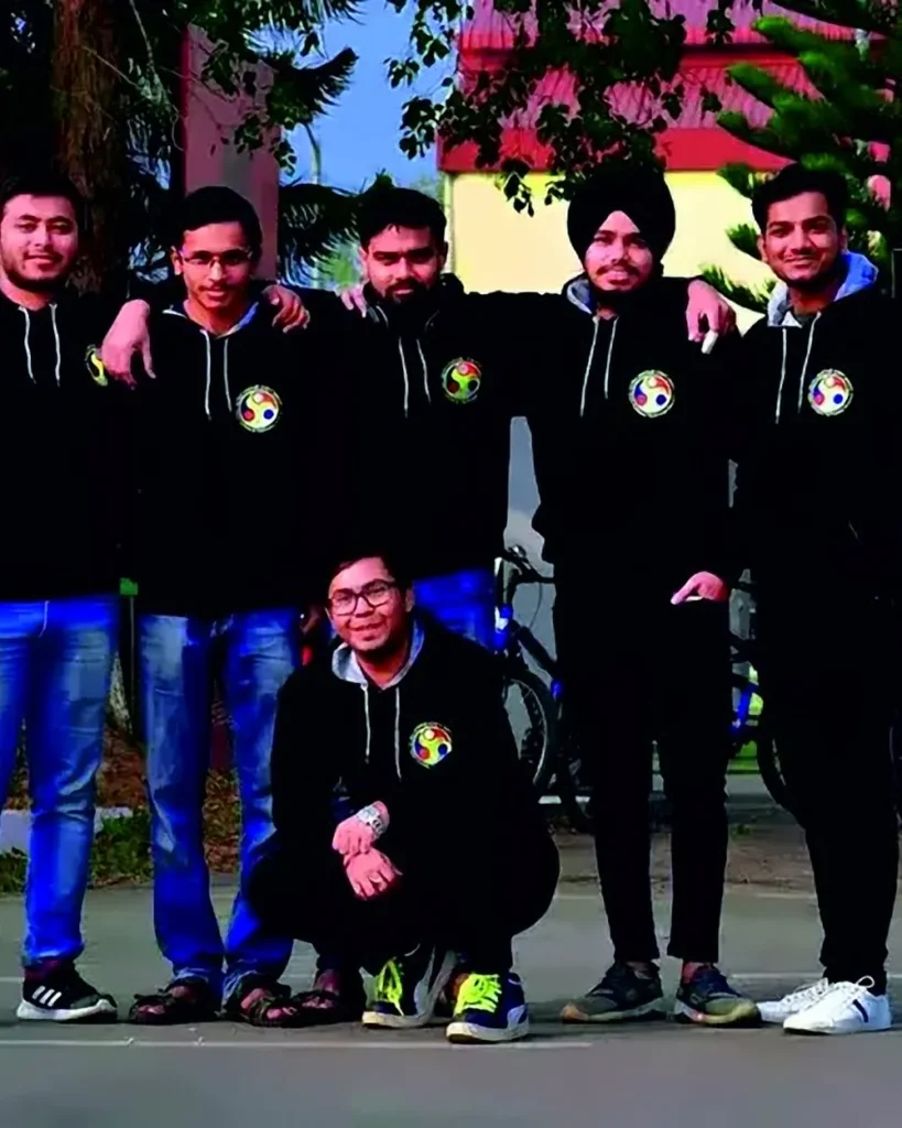 A group of young men wearing matching black hoodies with a round chest logo